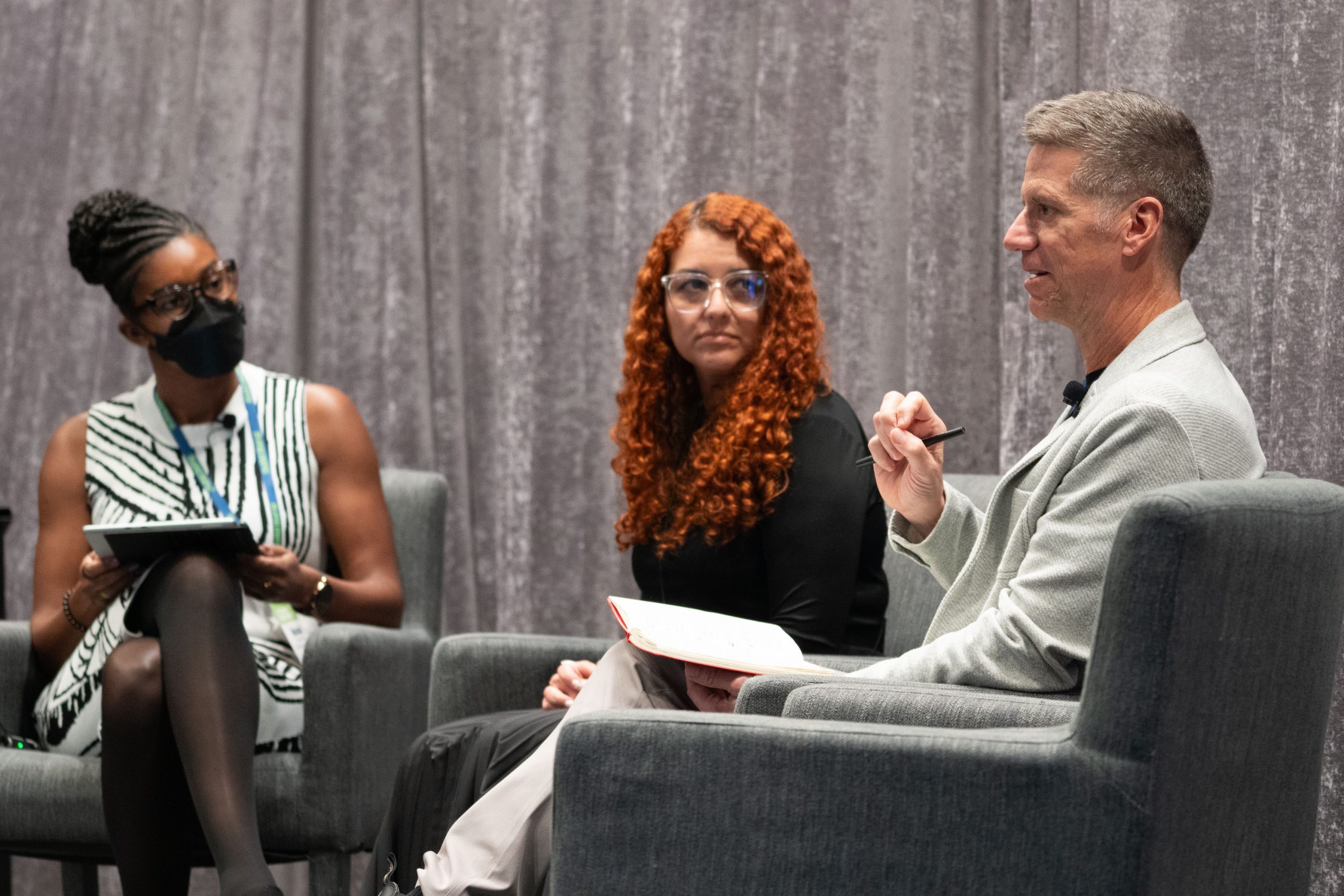 Panelists seated on stage during a conference discussion.