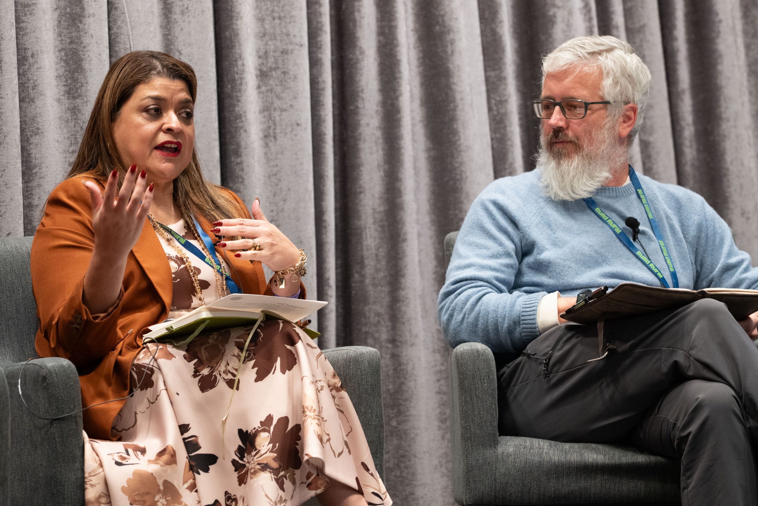 Panelists seated on stage during a conference discussion.