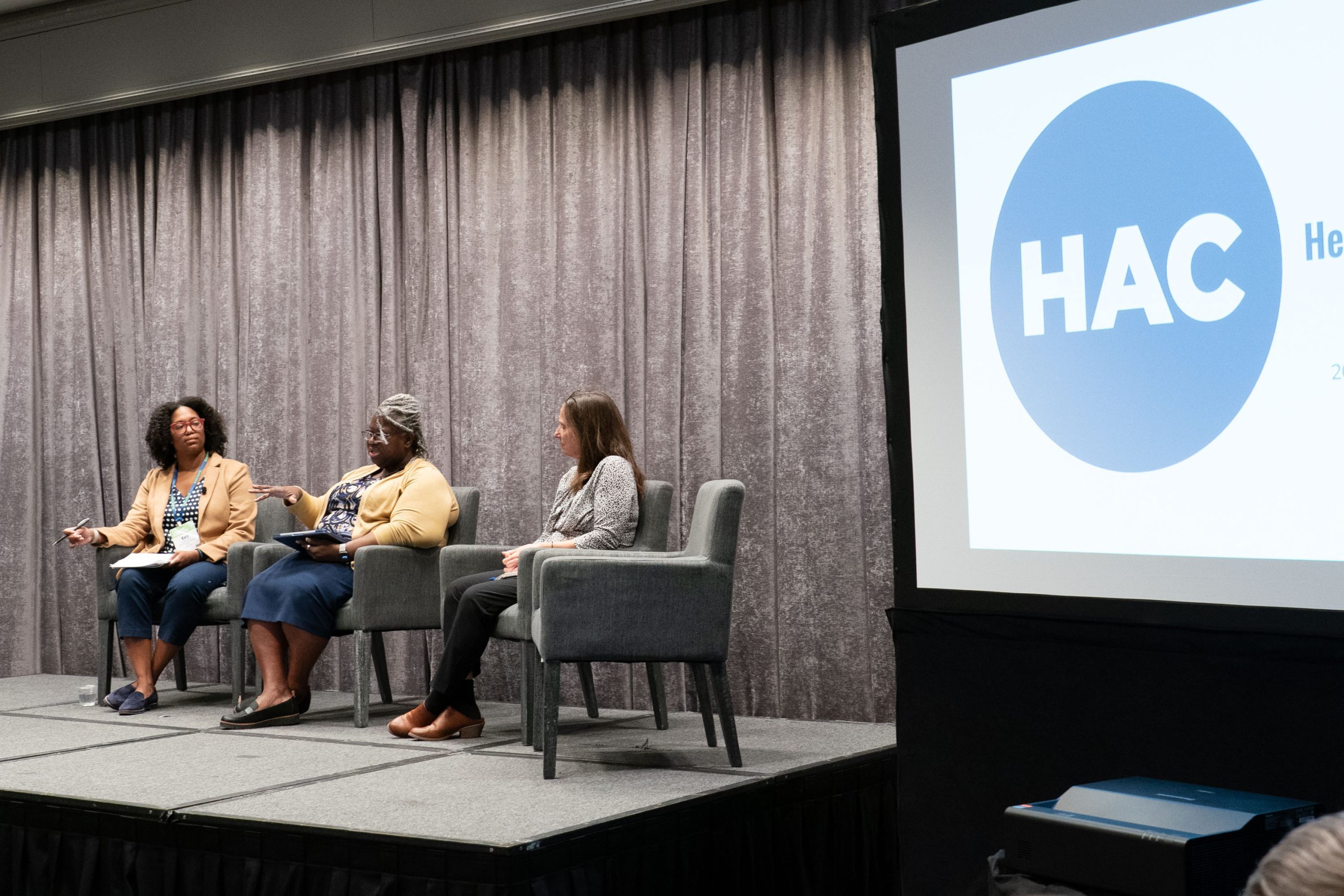 Panelists seated on stage during a conference discussion.