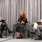 Panelists seated on stage during a conference discussion.