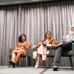 Panelists seated on stage during a conference discussion.