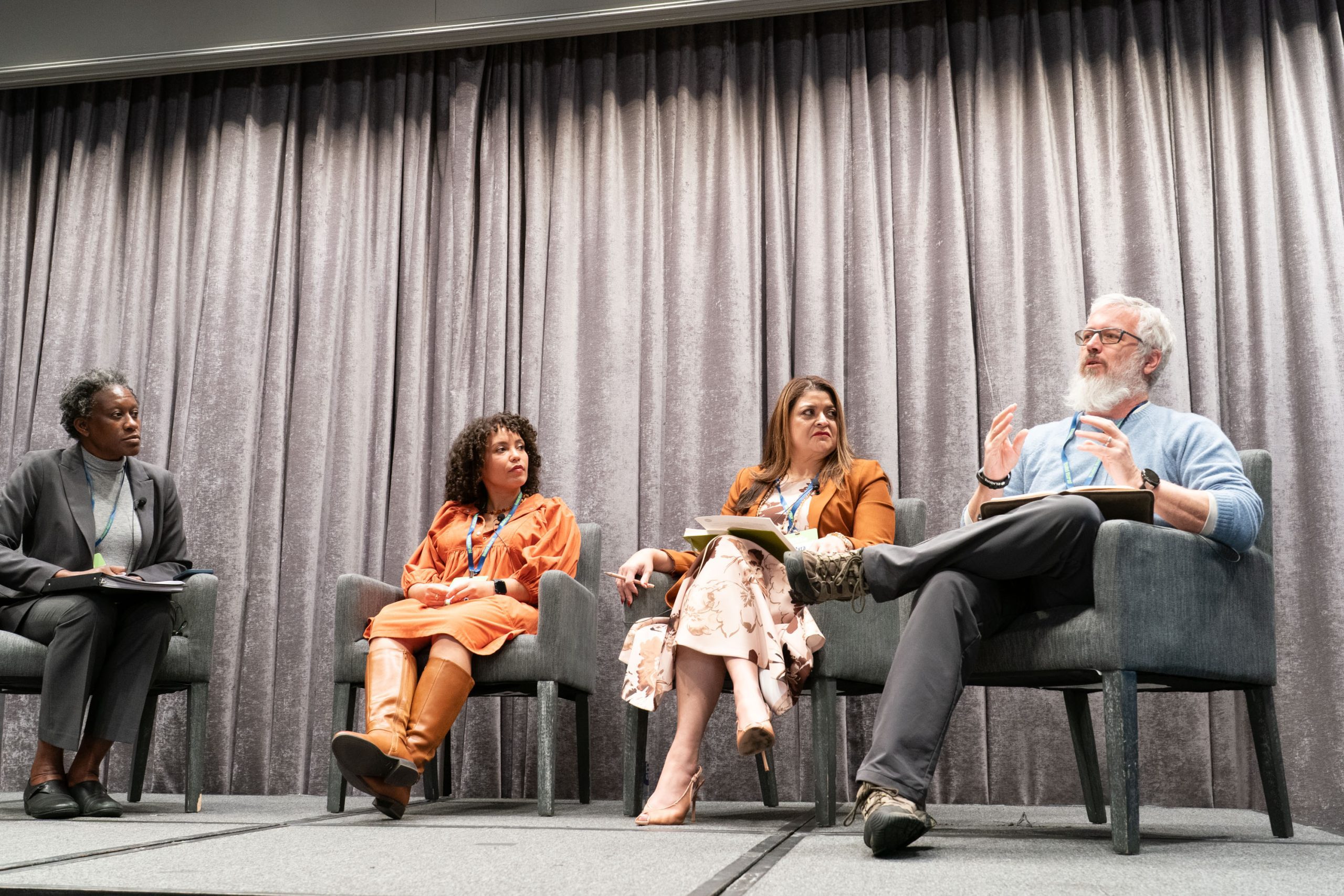 Panelists seated on stage during a conference discussion.
